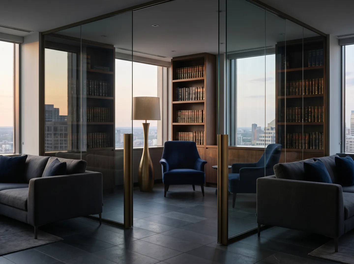 Sala de estar de un bufete moderno al atardecer, con biblioteca y vista a la ciudad